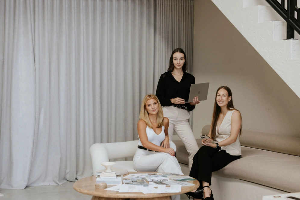 3 female marketing professionals smiling at the camera