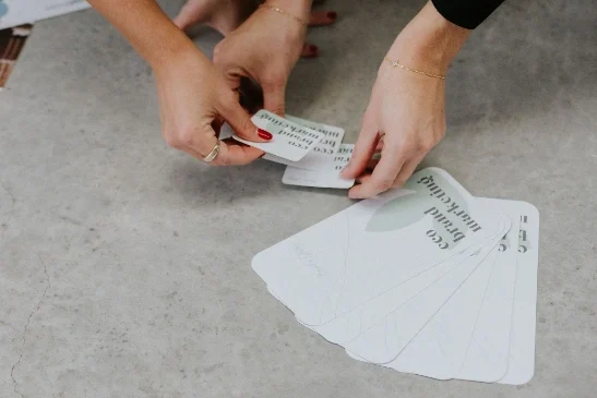 close up of hands placing brand business cards on the floor