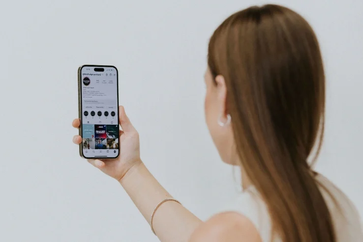 Brunette woman holding phone up to take a photo