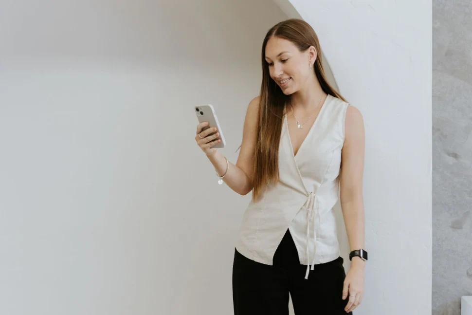 Long haired brunette marketing professional smiling at her phone