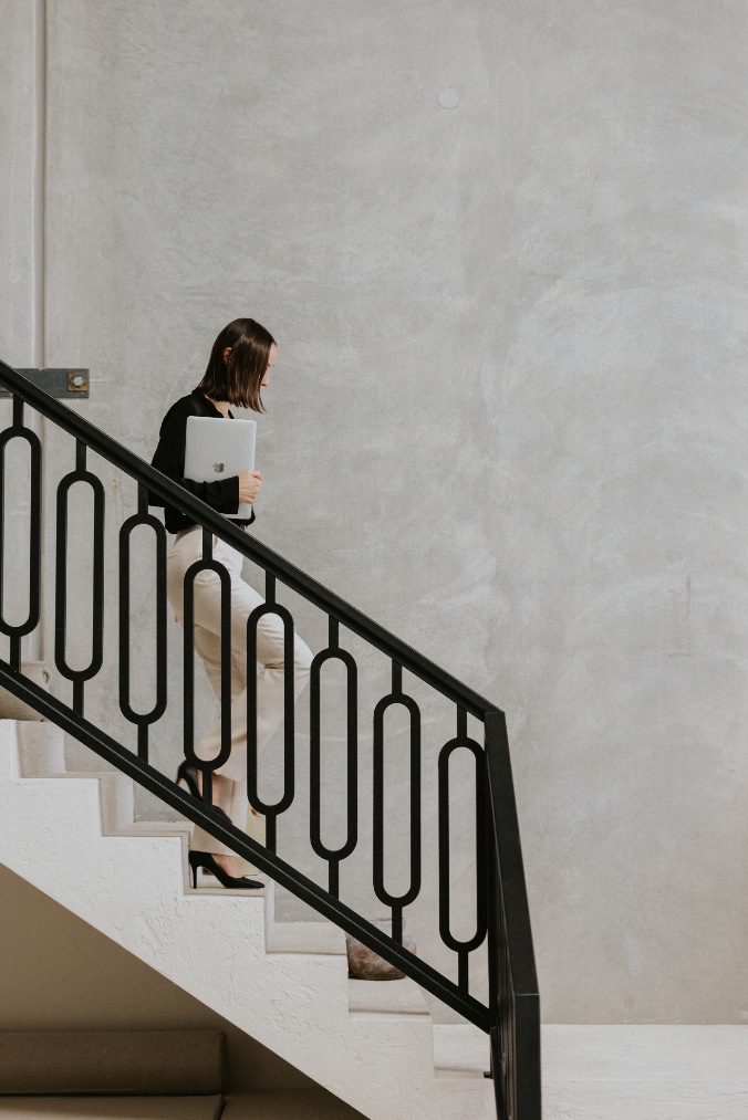 Short haired white female walking down staircase