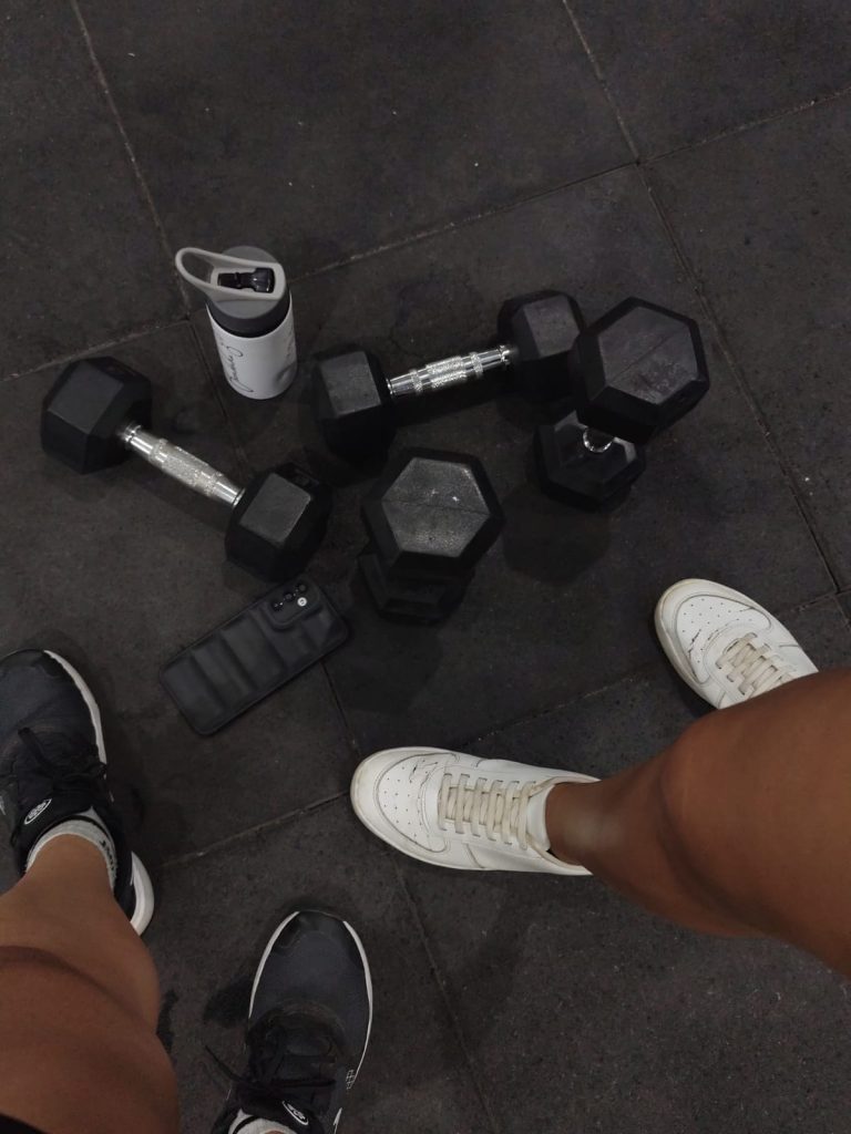 Weights on gym floor next to shoes